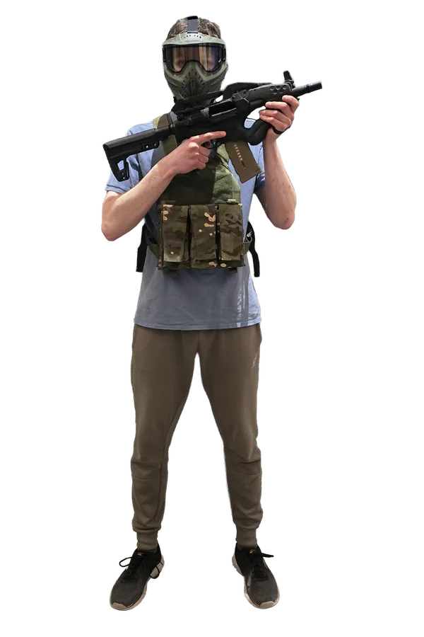 Speler in de volledige airsoft-huurkit: gezichtsmasker, tactisch vest met magazijntassen en een airsoft-replica